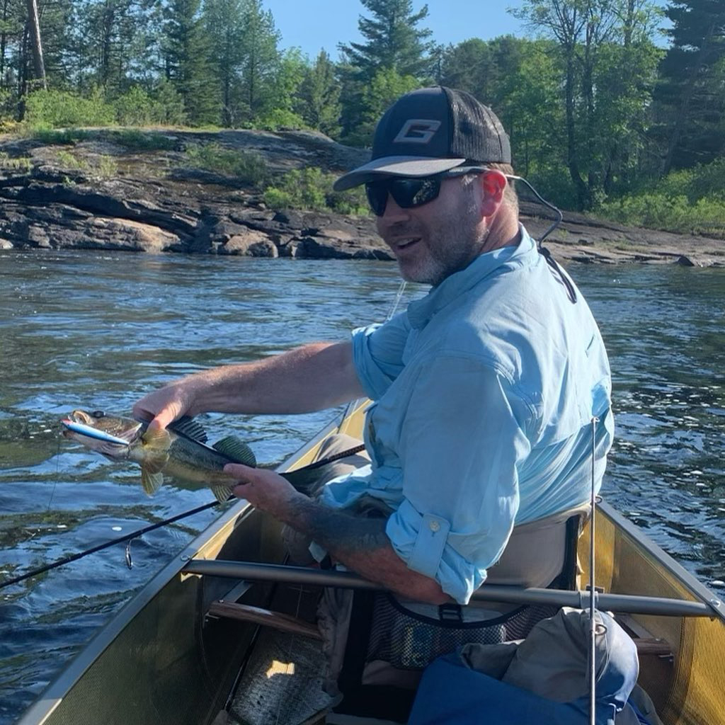 man in a canoe holding a fish