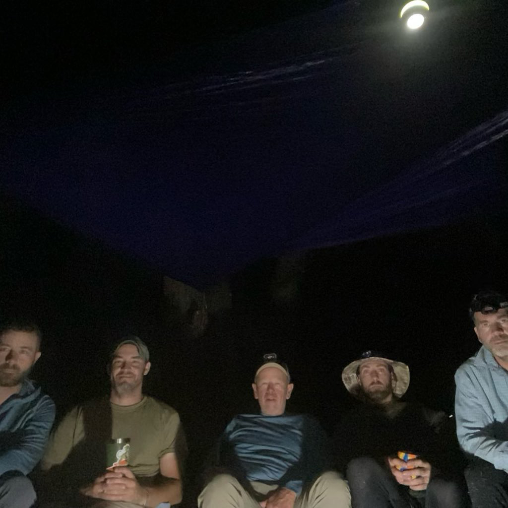 Men sitting in dark on canoe adventure