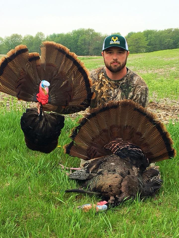 hunter with two turkeys fanned out