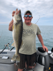 man holding a fish on a boat