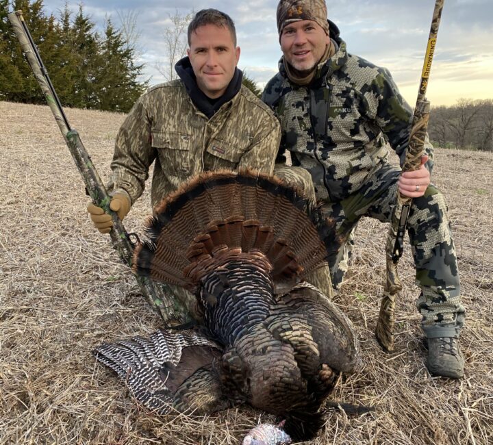 two hunters with turkey fanned out and shotguns